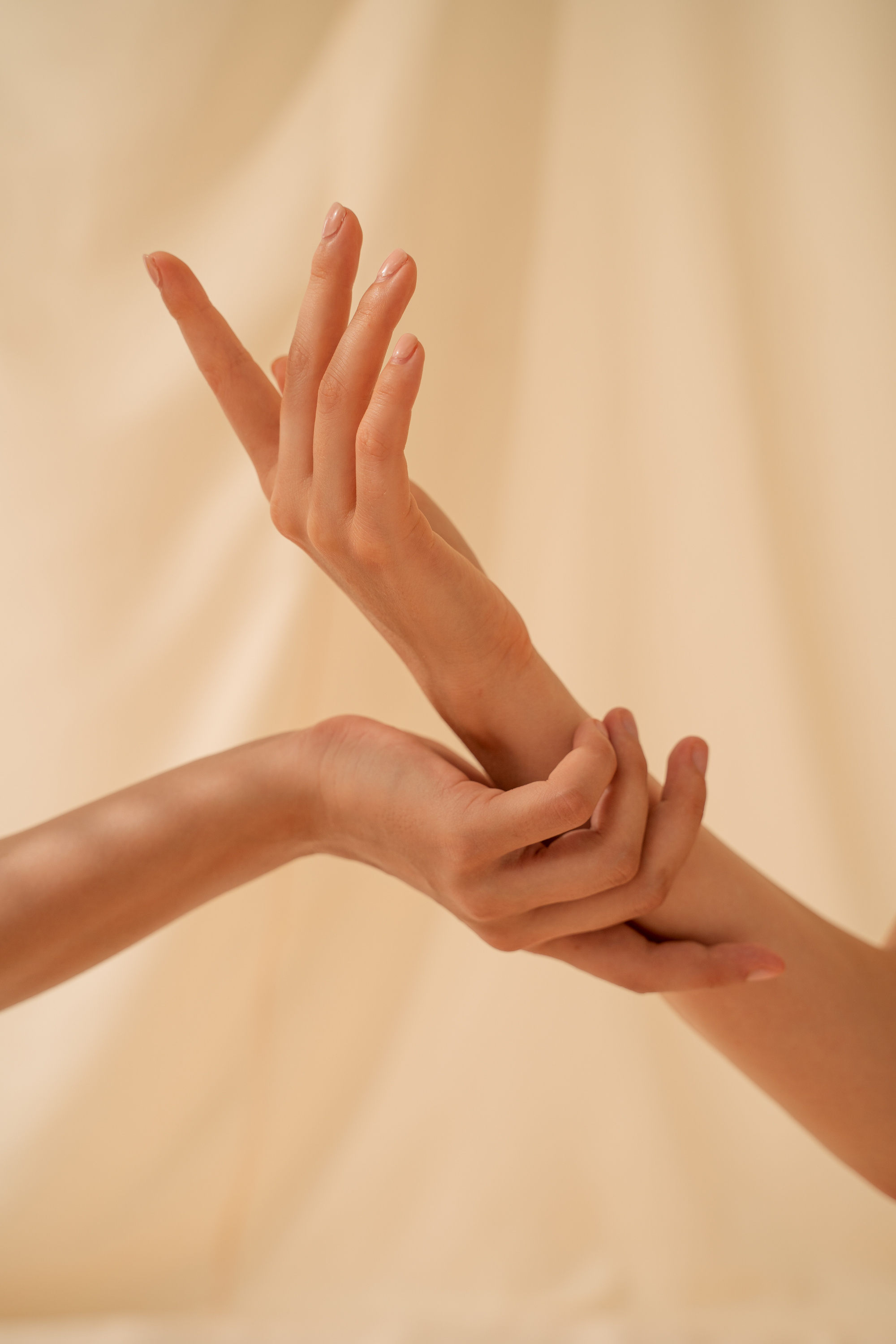 Two Person's Hands on Beige Background